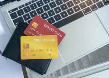 View of desk with credit card in the wallet on computer laptop