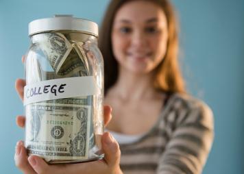 Hispanic girl holding a college savings jar