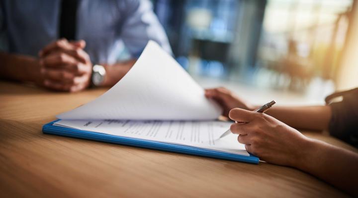 person holding pen checking documents