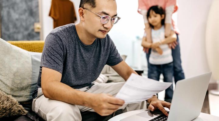 Man working on application while family watches