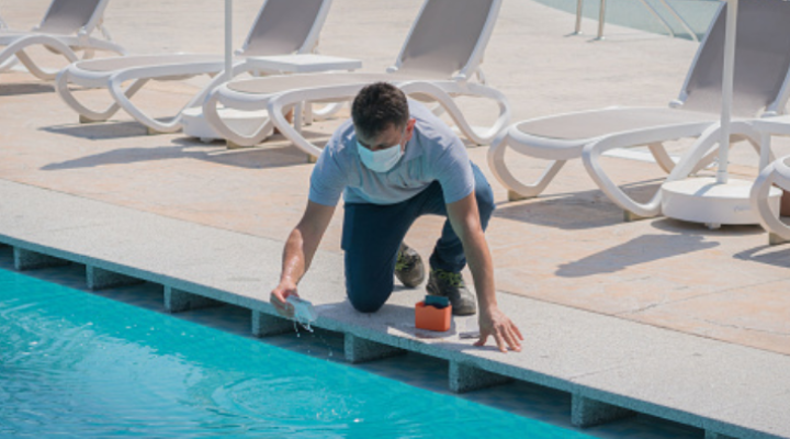 Hombre comprobando el nivel de pH en una piscina