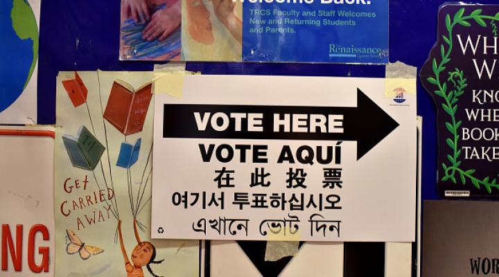 A sign in multiple languages saying "vote here"