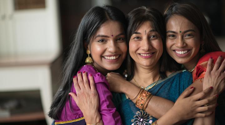 Retrato de una mujer india abrazando a sus hijas