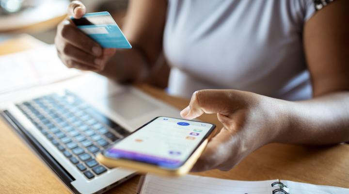 Primer plano de una mujer adulta de mediana edad usando una aplicación bancaria en su teléfono