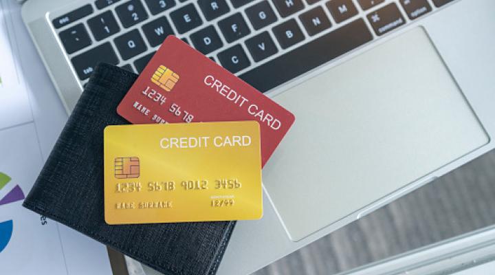 View of desk with credit card in the wallet on computer laptop